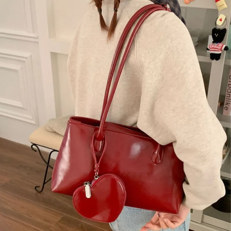 Damentasche mit Anhänger ⎜ Geräumige Schultertasche aus glänzendem Kunstleder mit Herz-Münzfach