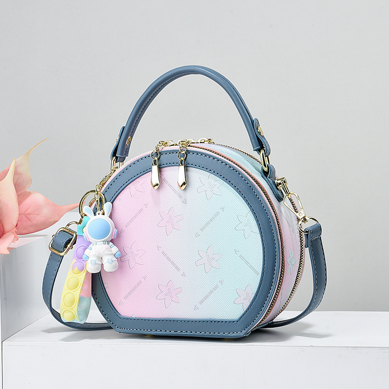 Handtasche für Damen ⎜ Runde Umhängetasche im Pastellstil mit verspieltem Anhänger für Alltag und Freizeit